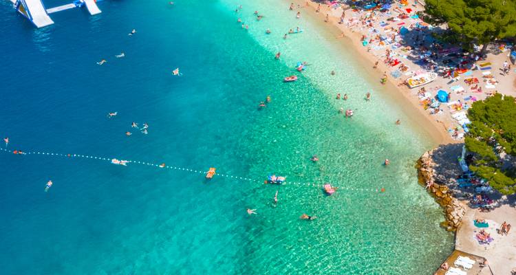 Strand mit Menschen, die schwimmen und sich sonnen.