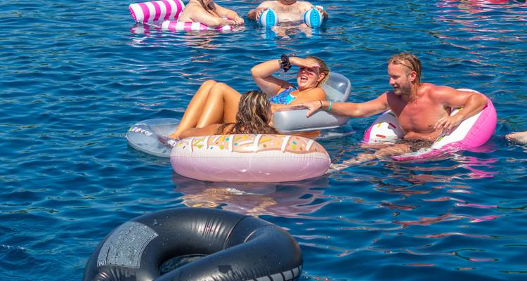 Menschen auf aufblasbaren Schwimmhilfen genießen das Wasser.