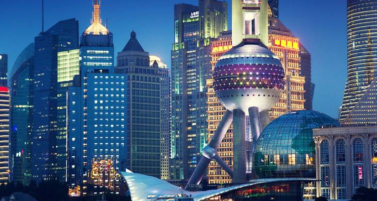 Nächtliche Skyline von Shanghai mit dem beleuchteten Oriental Pearl Tower und den umliegenden Wolkenkratzern