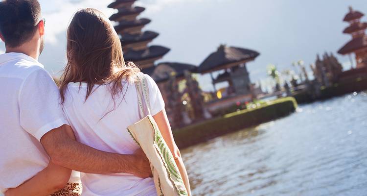 Couple standing lakeside admiring multi-tiered Balinese temple shrines
Couple debout au bord du lac admirant les sanctuaires de temples balinais à plusieurs niveaux