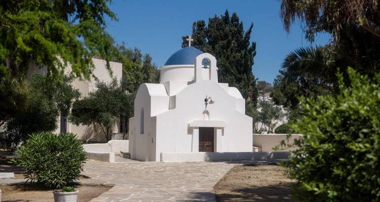 Église blanche avec un dôme bleu dans une cour.