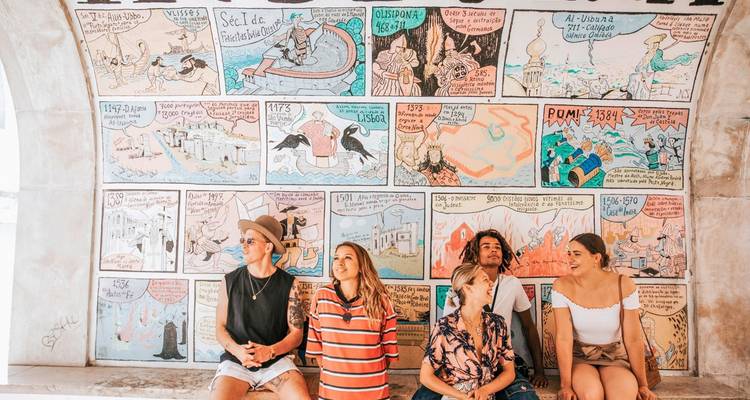 Group of people sitting under an arch with illustrated history mural.