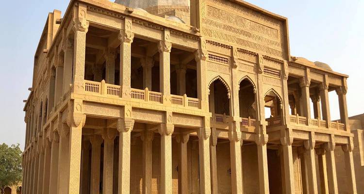 Mausolée en grès avec vérandas voûtées et motifs arabesques sculptés scintillant dans la lumière de l'après-midi