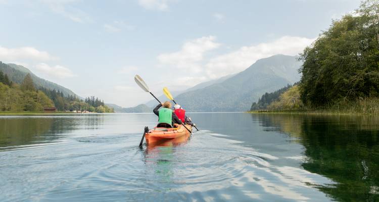 Des gens faisant du kayak sur un lac entouré de montagnes.