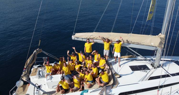 Groep mensen in gele shirts op een boot die genieten van hun excursie.