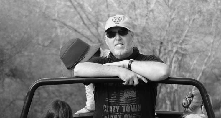 Man standing in a vehicle on a safari.