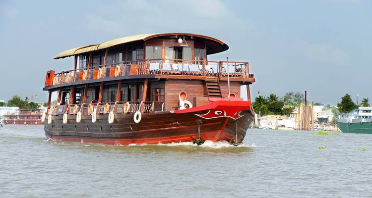 Ein großes Flusskreuzfahrtschiff auf einem breiten Fluss.