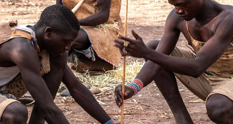 Twee mensen die een traditionele activiteit uitvoeren waarbij gereedschap wordt gebruikt.