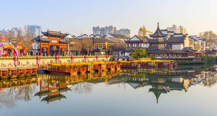Traditional Chinese buildings and boats along a canal.