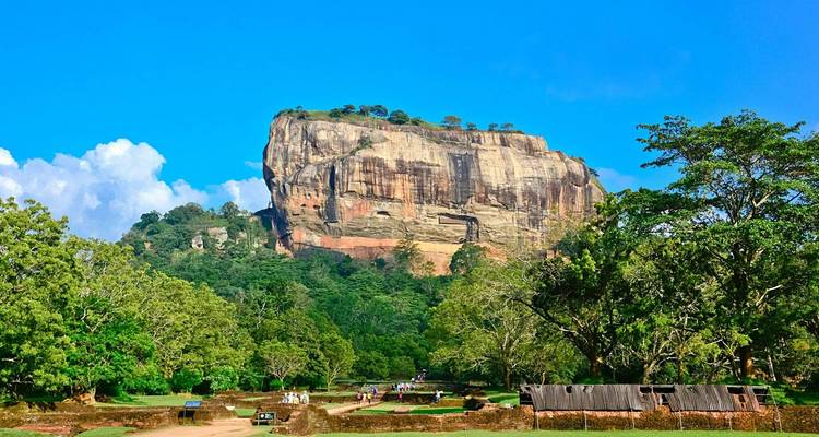 Forteresse rocheuse de Sigiriya entourée d'une végétation luxuriante et de ciels dégagés.
