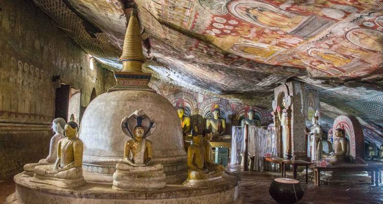 Temple bouddhiste avec des peintures de plafond ornées et des statues.