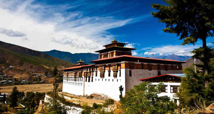 Une forteresse bhoutanaise traditionnelle entourée de montagnes.