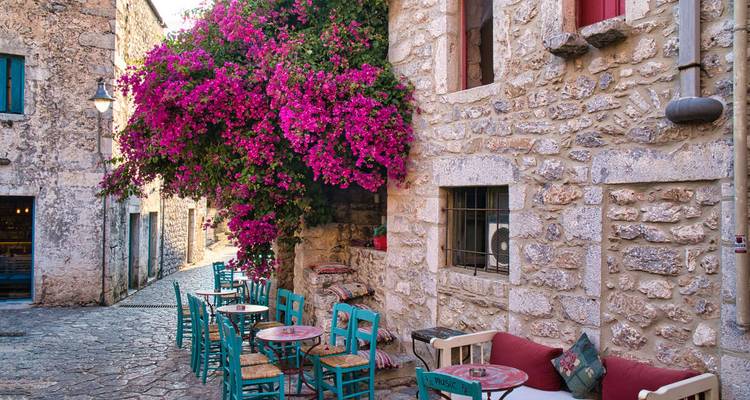 Charmante rue avec des bougainvilliers colorés et des places assises en plein air.