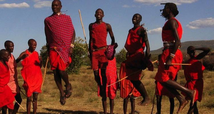 Groupe de personnes Maasaï sautant et vêtues d'habits traditionnels.