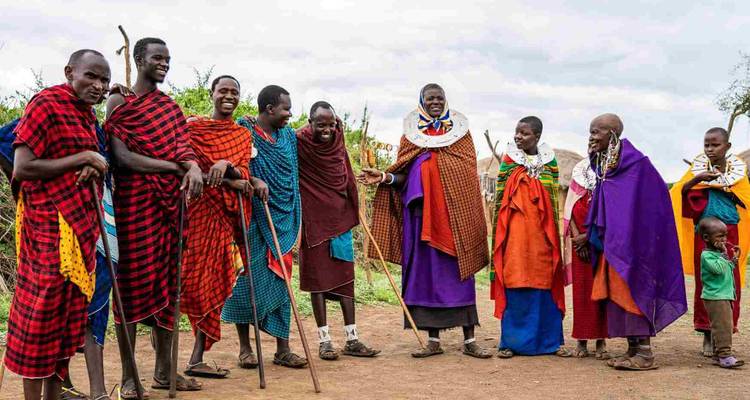 Des personnes Maasaï en tenue traditionnelle se rassemblant et souriant.