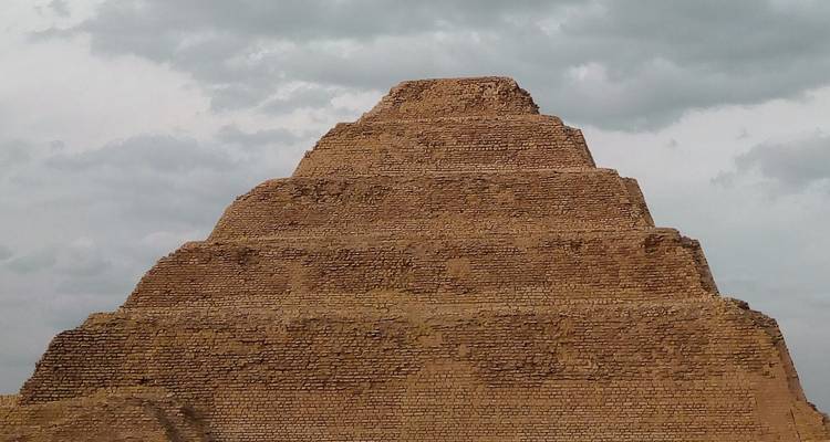 La Pyramide à degrés de Djéser en Égypte sous un ciel nuageux.