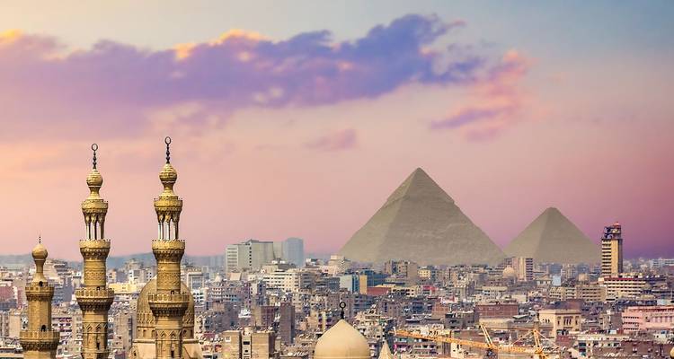 Horizon du Caire avec les pyramides en arrière-plan au coucher du soleil.