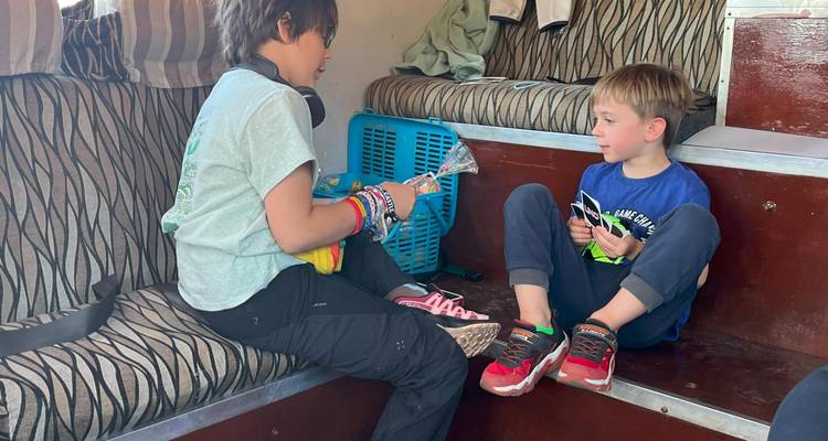 Kinderen die kaarten spelen in een safariwagen