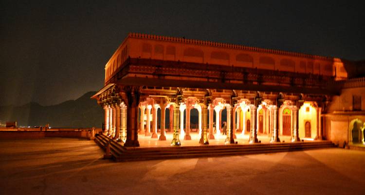 Illuminated columns of a historic building at night.