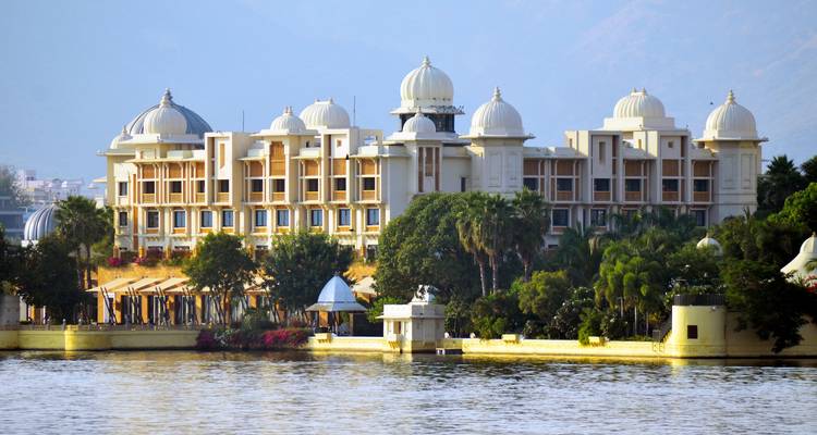 A lakeside hotel with surrounding trees and domes.