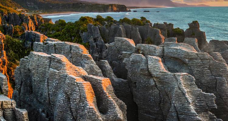 Unieke rotsformaties bekend als Pancake Rocks met de oceaan op de achtergrond.