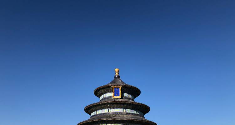 Temple of Heaven's iconic roof under a blue sky.