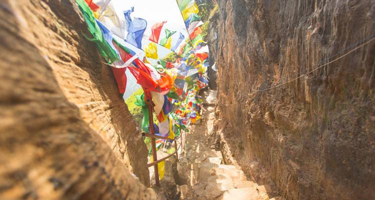 Colorful prayer flags along a rocky path.