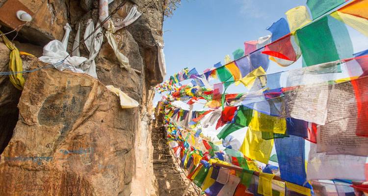 Prayer flags spanning between rocky cliffs.