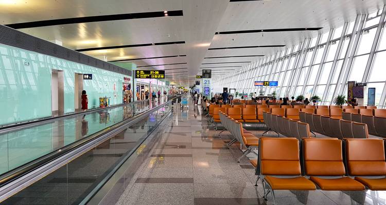 Aérogare moderne avec passagers et sièges.