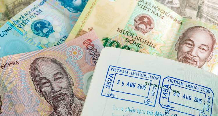 Monnaie vietnamienne et passeport avec tampons d'immigration.