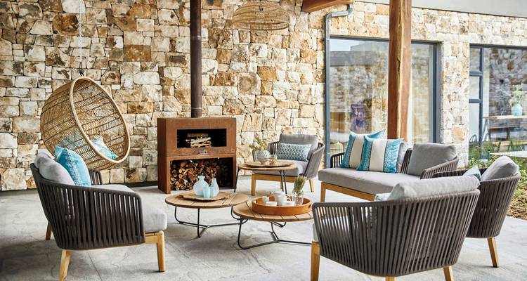 Interior seating area with stone walls and wooden furniture.