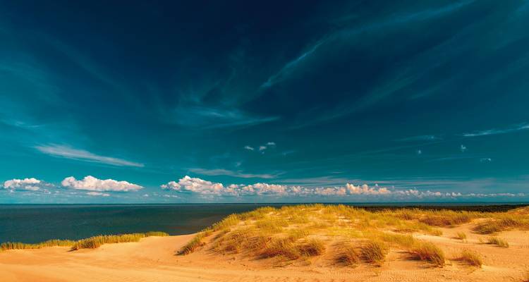 Zandduinen en lucht in een rustig landschap.