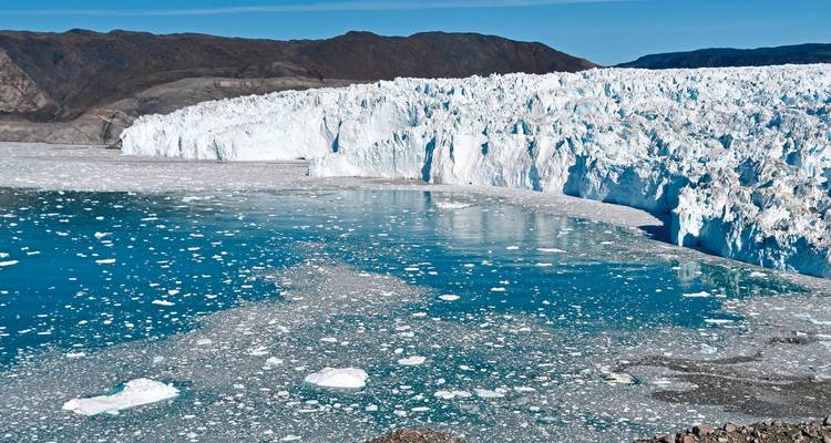 Glaciar de parto con aguas heladas bajo un cielo despejado.