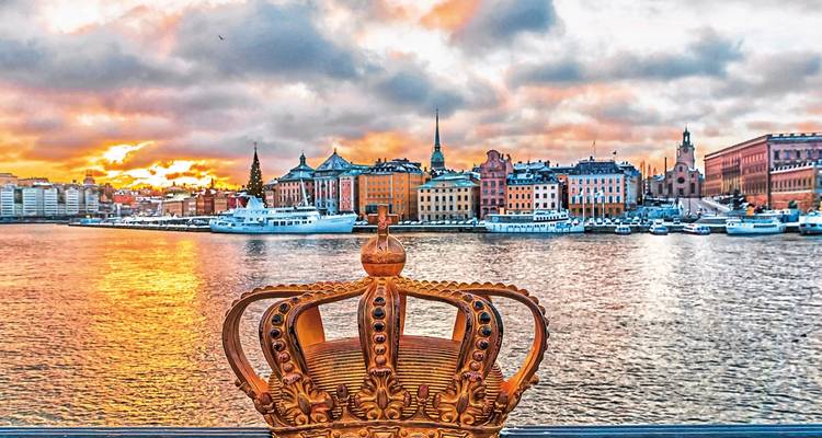 Paysage urbain de Stockholm au coucher du soleil avec une sculpture de couronne au premier plan.