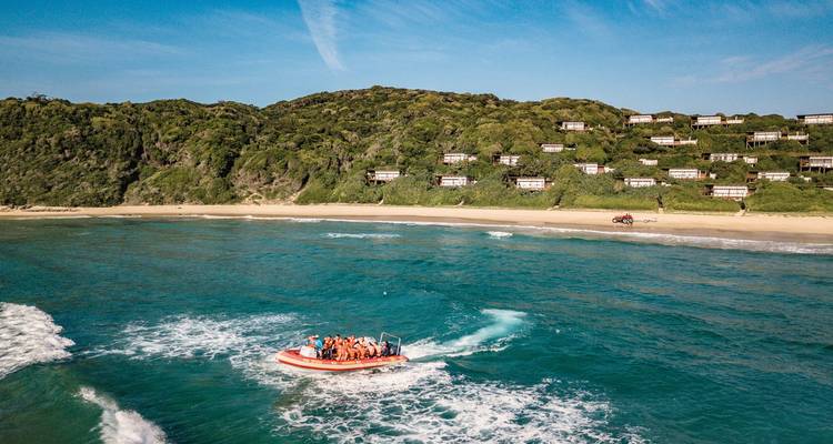 Vue aérienne d'une zone côtière avec un bateau au premier plan.