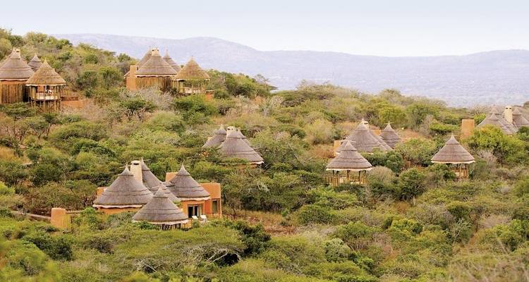 Huttes nichées dans un paysage vallonné et verdoyant.