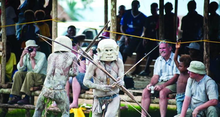 Menschen in traditionellen Kostümen führen ein Ritual auf.