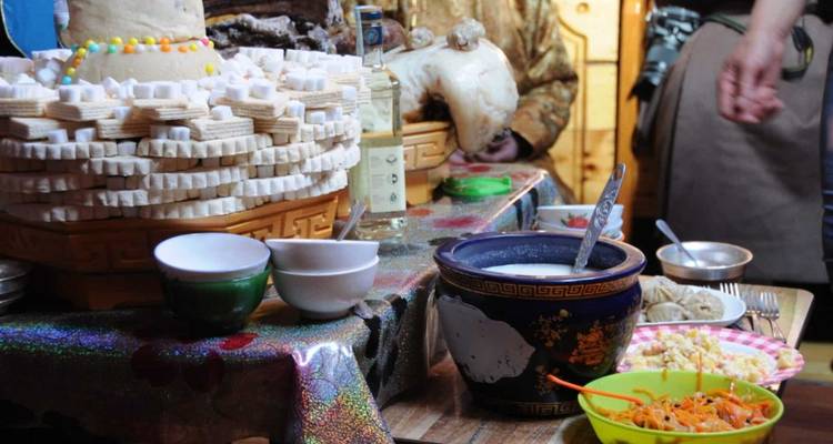 Table filled with traditional foods inside a yurt.