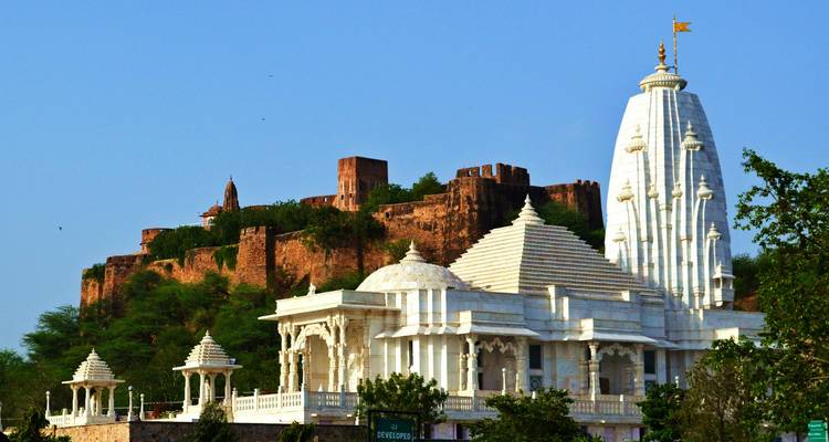 Un temple de marbre blanc avec un fort en arrière-plan.