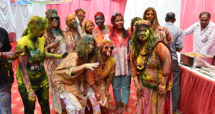 Groupe de personnes couvertes de poudre colorée pendant un festival.