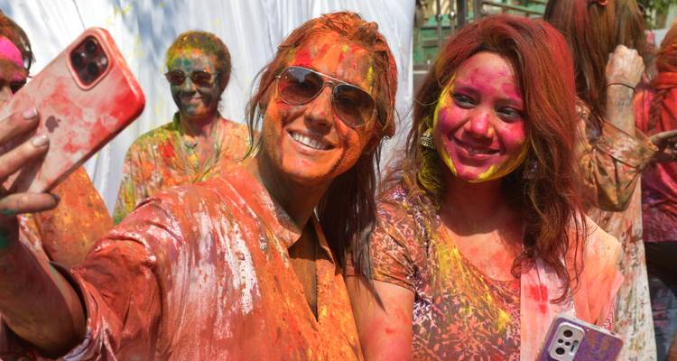 Deux femmes prenant un selfie, couvertes de poudre colorée.