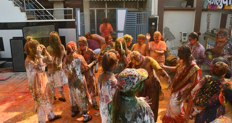 Groupe de personnes célébrant avec de la poudre colorée à l'extérieur.
