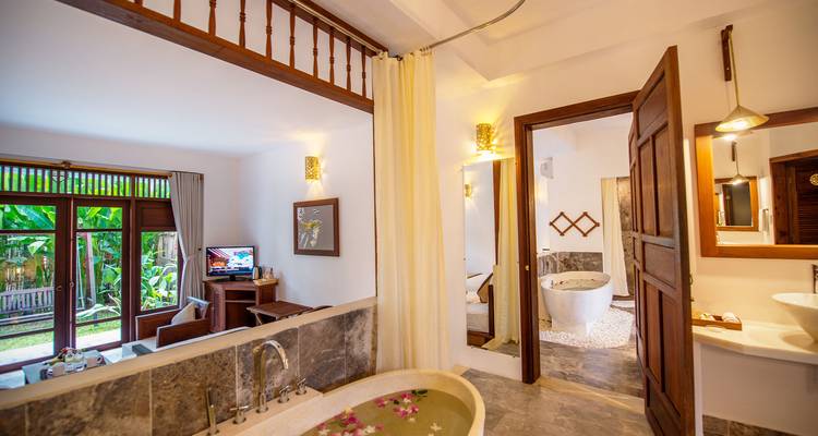 Intérieur de salle de bain de complexe hôtelier avec vue sur le jardin.