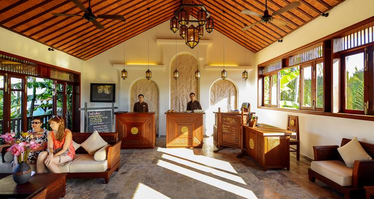 Hall d'hôtel avec personnel et clients, décoré d'éléments traditionnels.