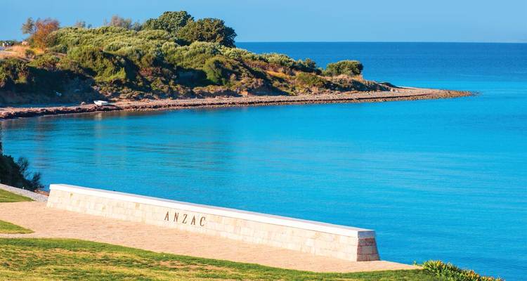 Peaceful turquoise bay at ANZAC Cove with memorial wall beside clear blue sea