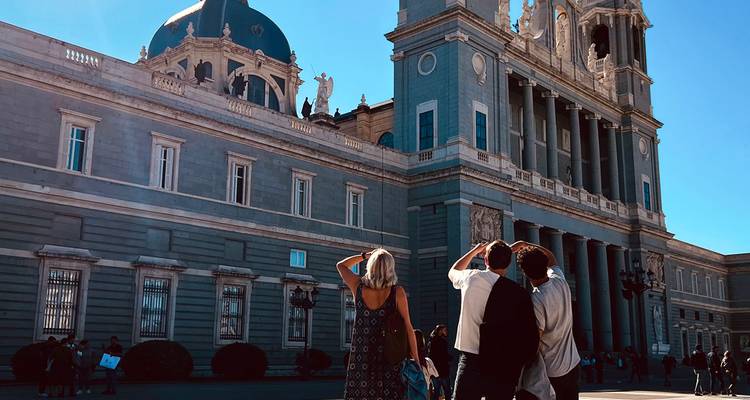 Les voyageurs contemplent le Palais Royal de Madrid par une journée de ciel bleu éclatant.