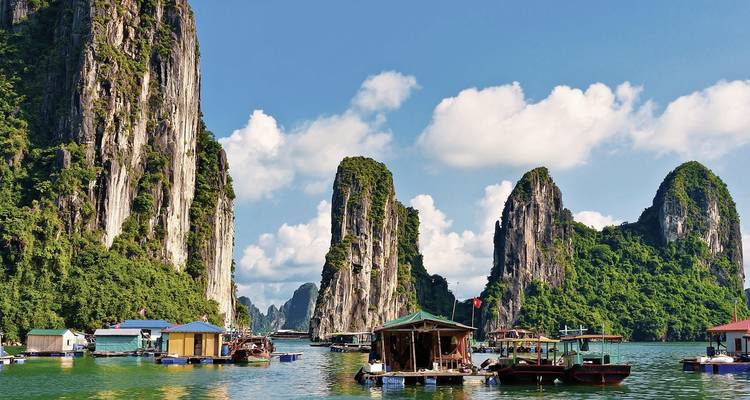 Floating village with limestone karsts in the background.