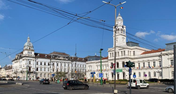 Offener Platz mit historischen Gebäuden unter blauem Himmel.