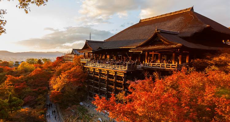 Kiyomizu-dera-Tempel umgeben von Herbstlaub bei Sonnenuntergang.