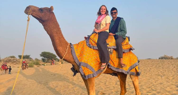 Ein Paar reitet auf einem Kamel in der Wüste